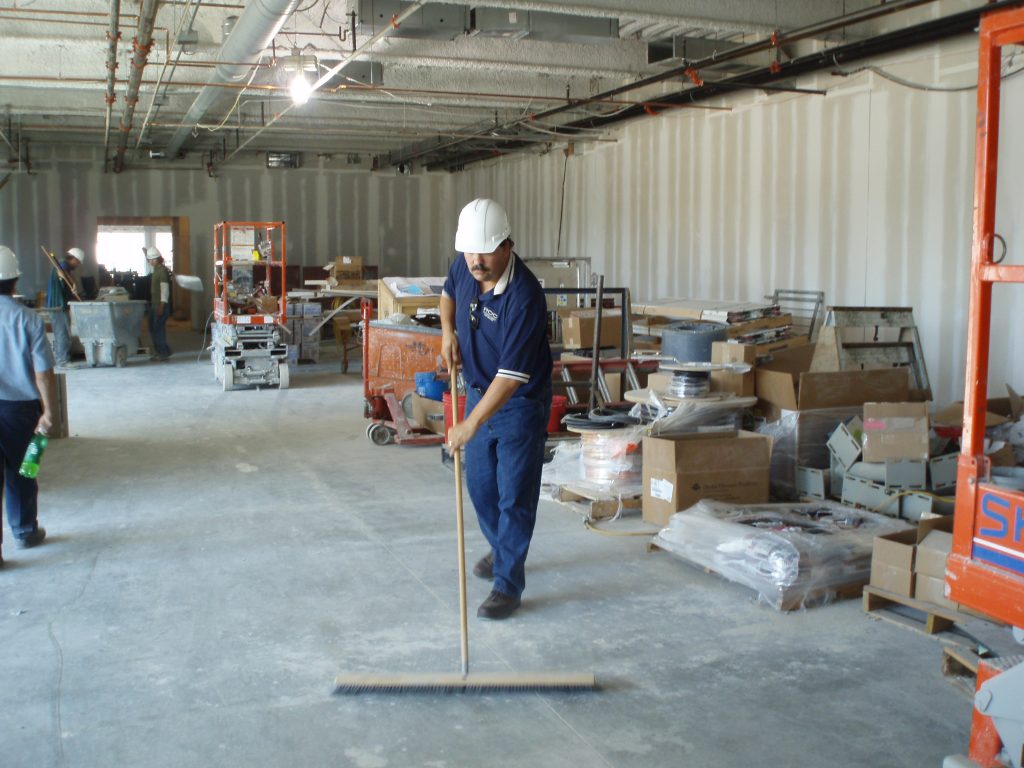 ROC Construction Cleaning | Man sweeping jobsite