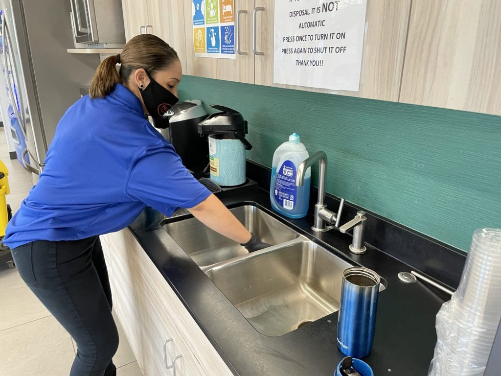 woman cleaning office sink