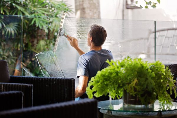 man cleaning interior windows in office