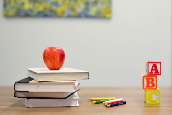 apple on pile of books on school desk