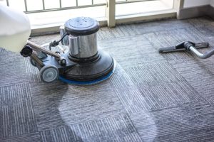professional grade carpet cleaning machine being used on a business office floor by a commercial cleaner
