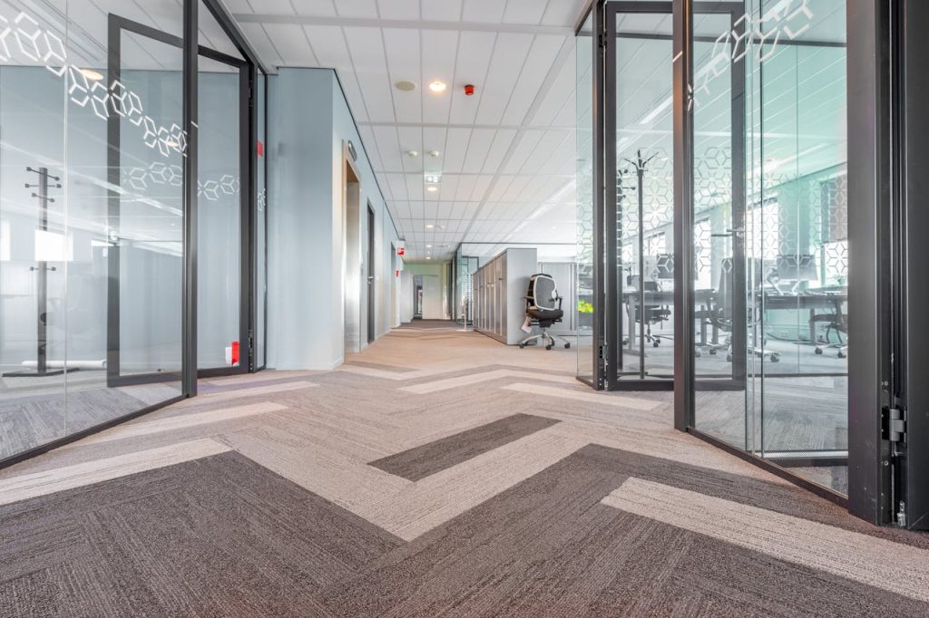 clean carpet inside a business office hallway with glass window room dividers